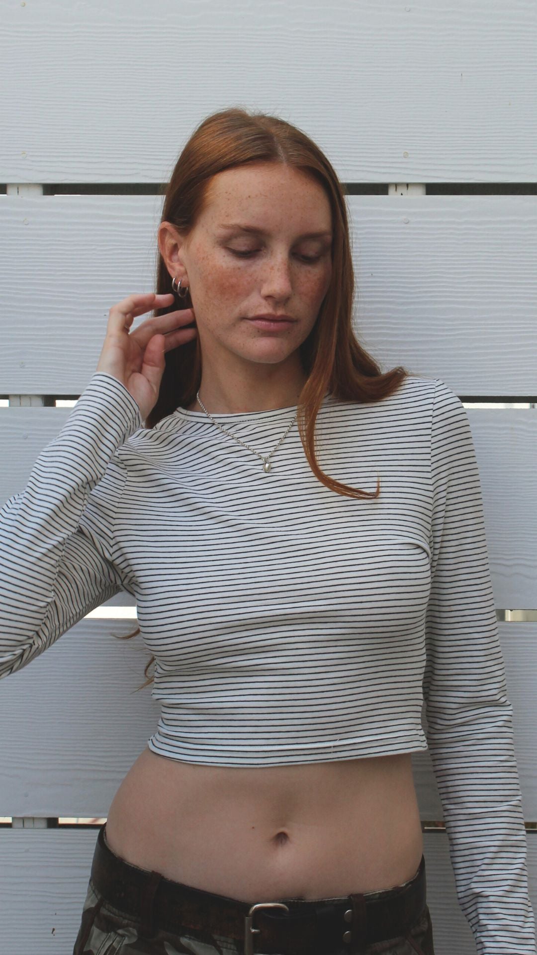 Model in off-white striped long sleeve cotton-spandex crop top, showing midriff.