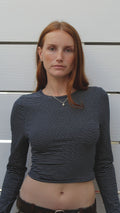 Model wearing a navy and off-white striped long-sleeve cotton-spandex crop top.