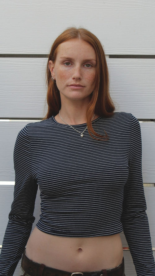 Model wearing a navy and off-white striped long-sleeve cotton-spandex crop top.