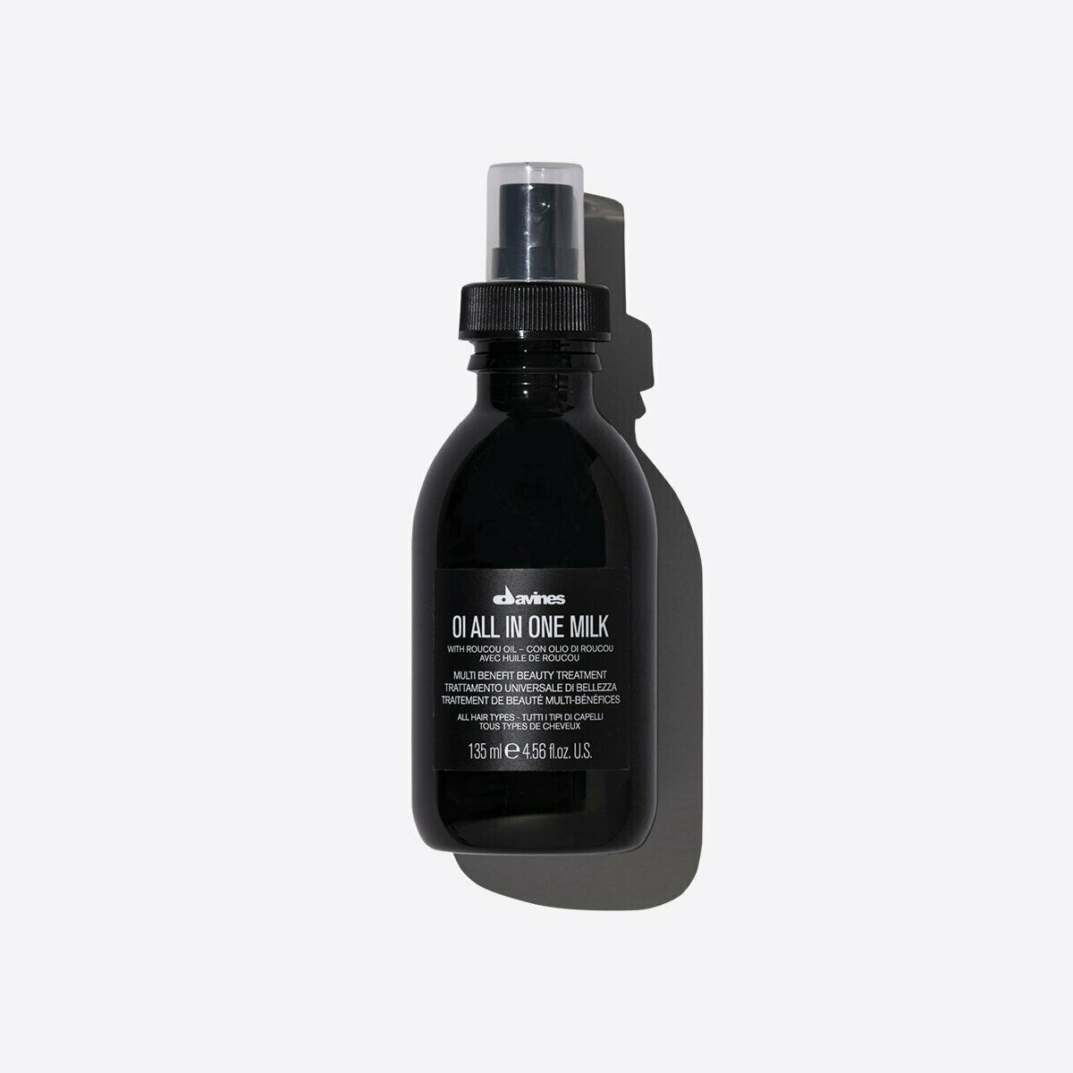 Davines OI All In One Milk, a black 135ml spray bottle with white text, casting a shadow.