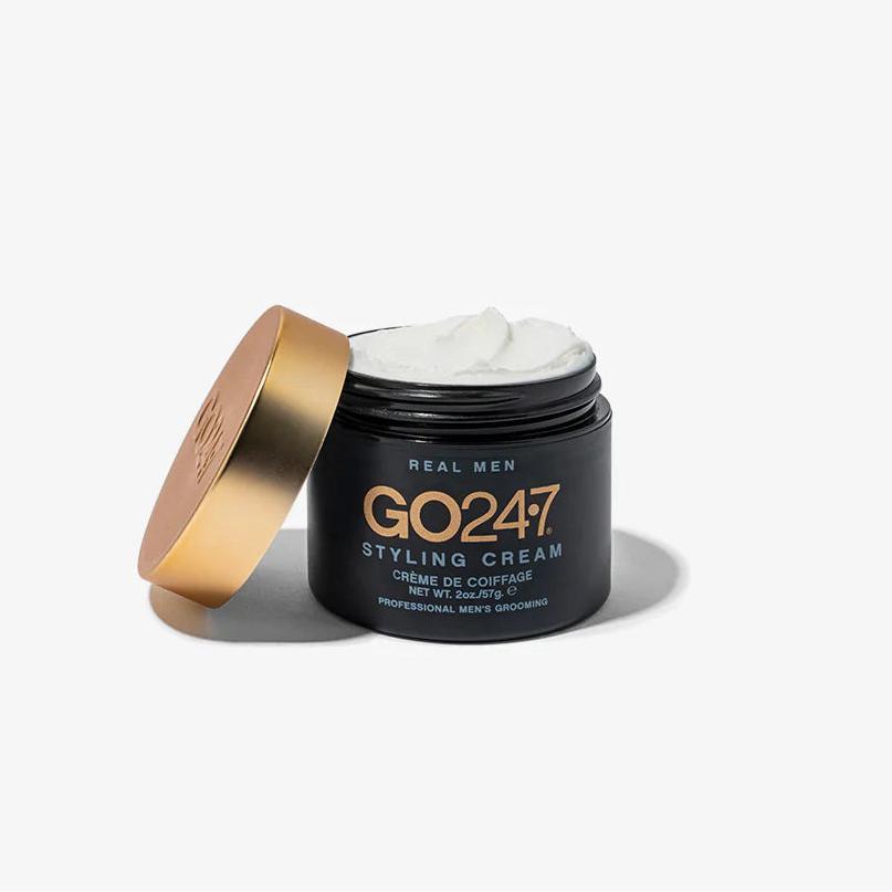 GO24•7 Styling Cream in a matte black jar with a gold lid, open to reveal white cream.
