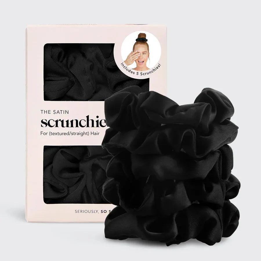Kitsch 5-piece set of black satin scrunchies, stacked next to their pink and white packaging.
