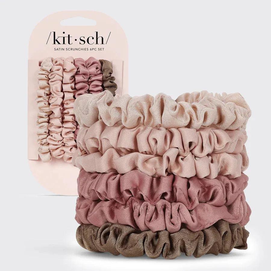 Kitsch 6-piece satin scrunchie set in various neutral and pink shades, stacked next to its packaging.