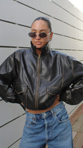 Model in a black collared faux leather Motomermaid Jacket with front pockets and a zipper.