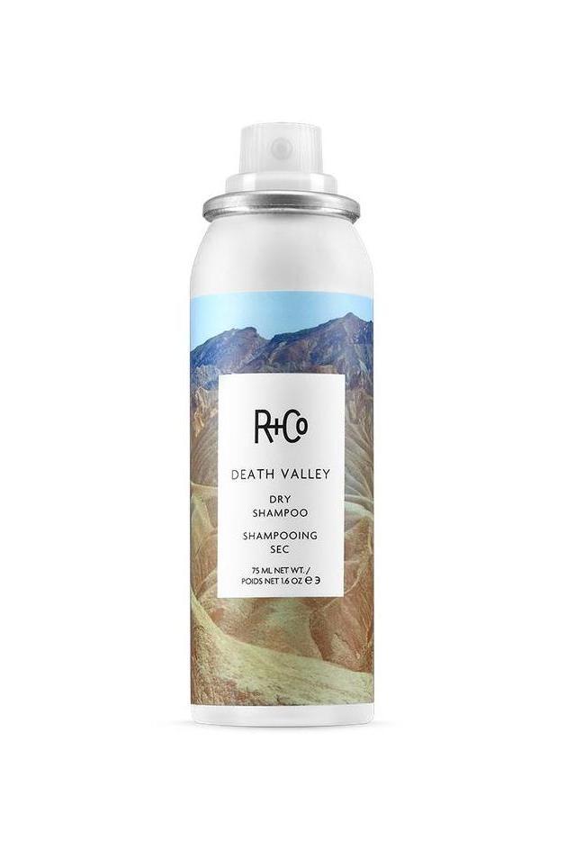 R+Co Death Valley Dry Shampoo MINI, a white aerosol can with a desert mountain landscape label.