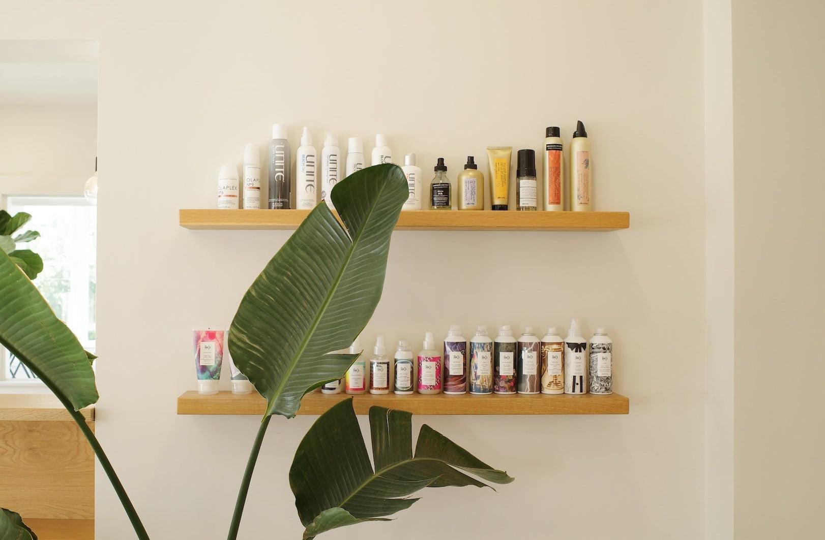 Discover premium hair care products displayed on sleek wooden shelves at Salty Mane Hair Salon.