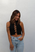 Woman in black ribbed front tie cropped tank top, size S, with light wash jeans.