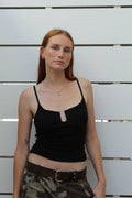 Model in black Soho Top, a shirred wired trim cami of cotton-spandex blend, paired with camo pants.