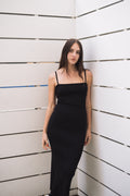 Model in a black ribbed open-back midi dress with spaghetti straps, size S.